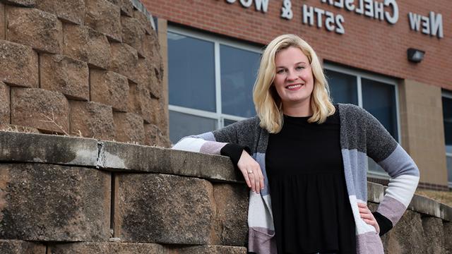 Megan Segraves poses in front of New Chelsea Elementary School at 25th and Wood in 堪萨斯 City, 堪萨斯.